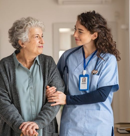 Young caregiver helping senior woman walking. Nurse assisting her old woman patient at nursing home. Senior woman with walking stick being helped by nurse at home.
